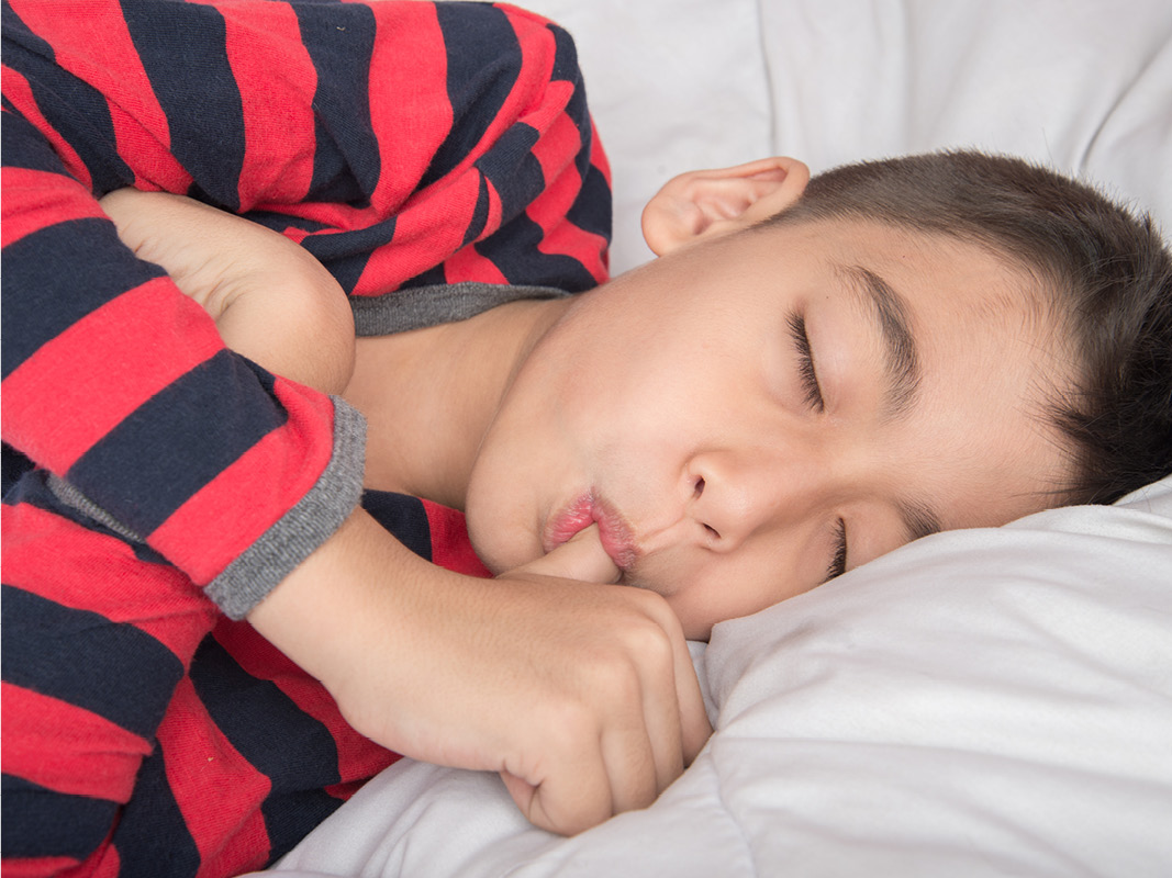 Young boy sleeping with his thumb in his mouth