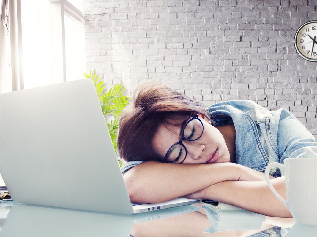 Young woman falling asleep on her laptop