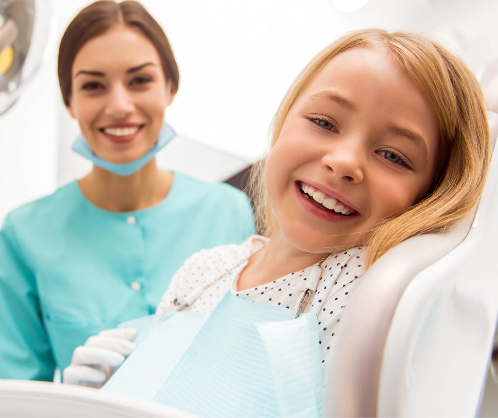 Young girl and female hygienist smiling
